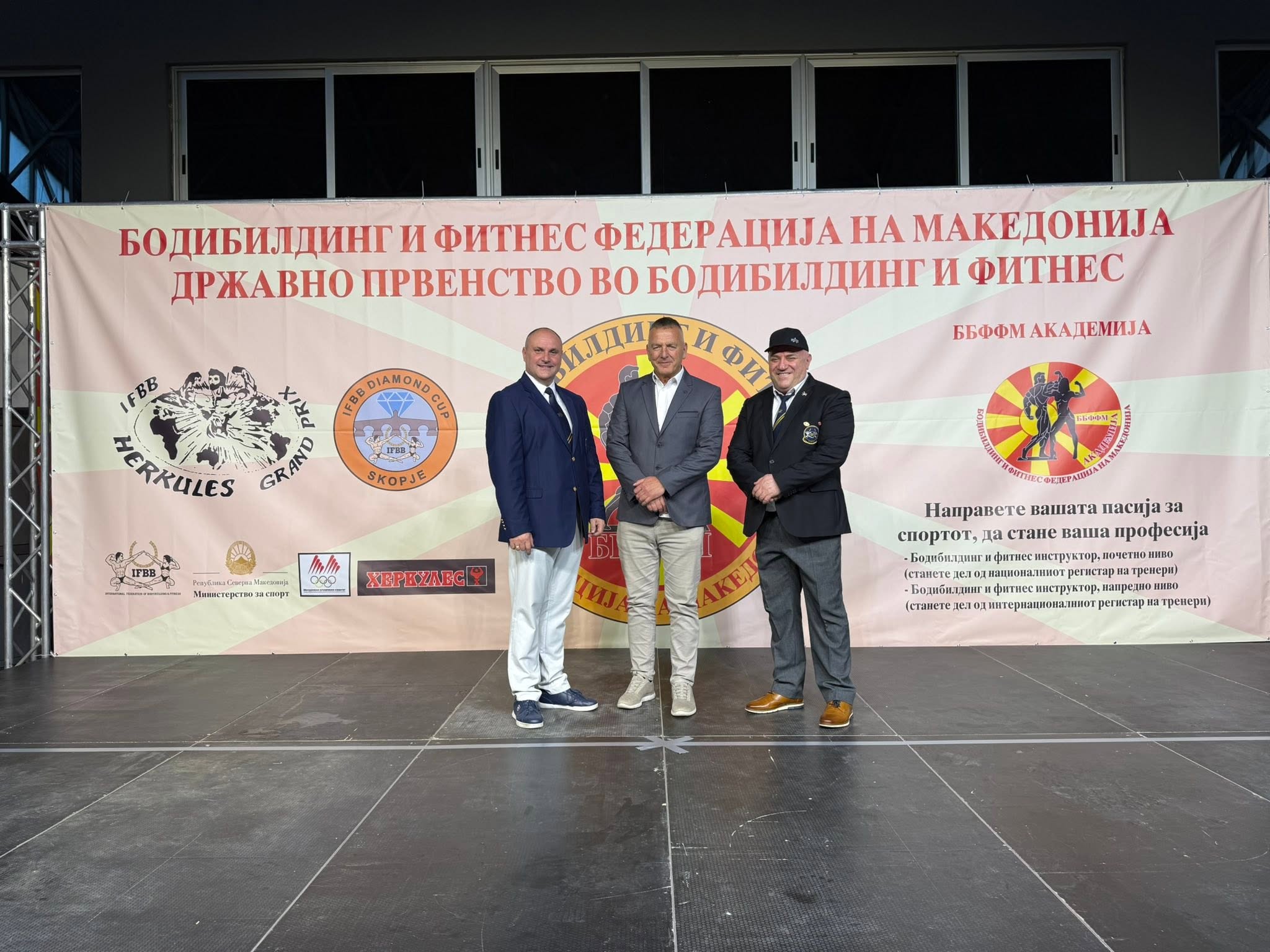 Tre burra në skenë para banerit të kampionatit kombëtar të Maqedonisë së Veriut.