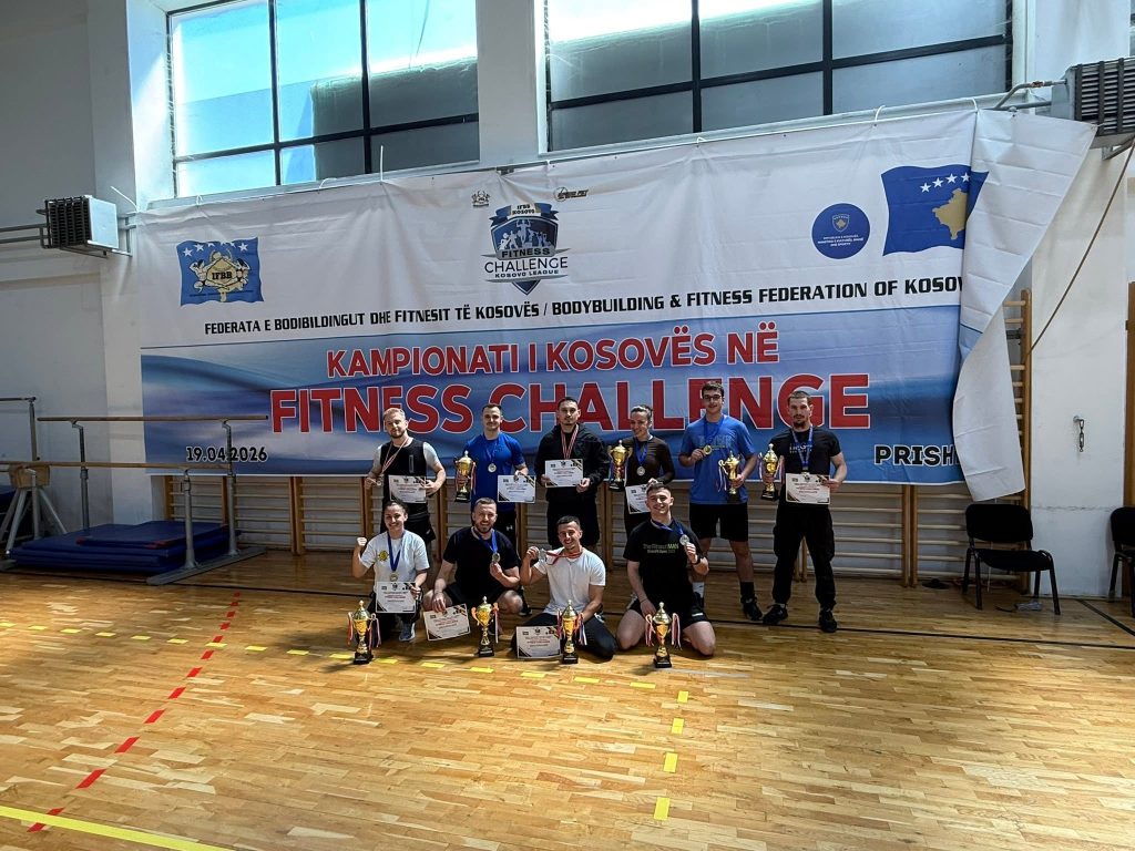 Pobednik sa trofejem ispred banera Prvenstva Kosova u Fitness Challenge.