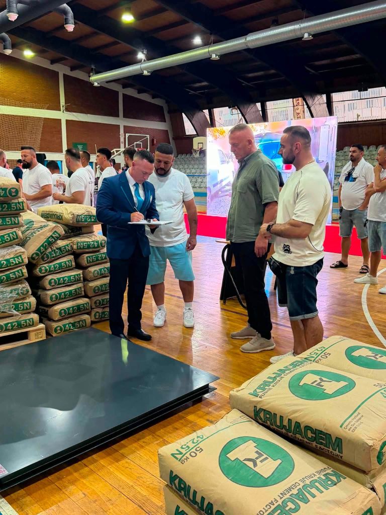 The official and several men next to the weight sacks.