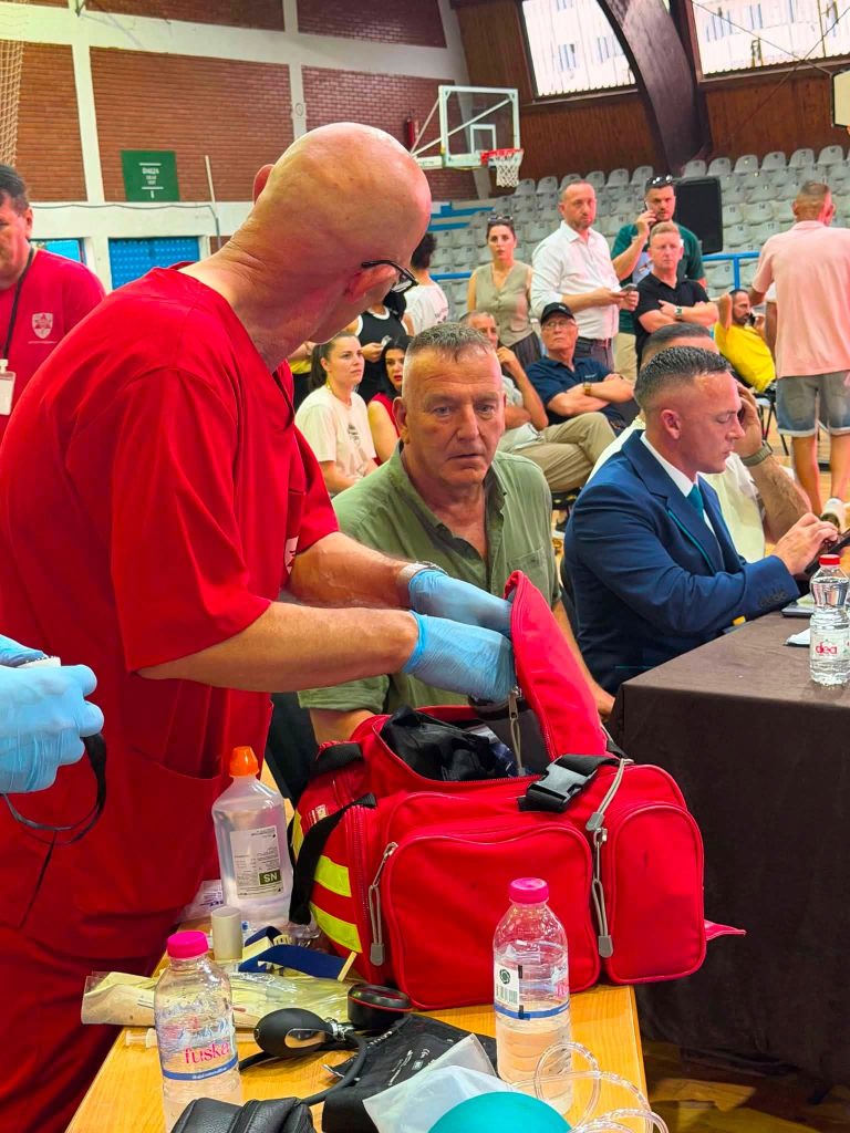 A doctor in a red uniform preparing the first-aid bag.