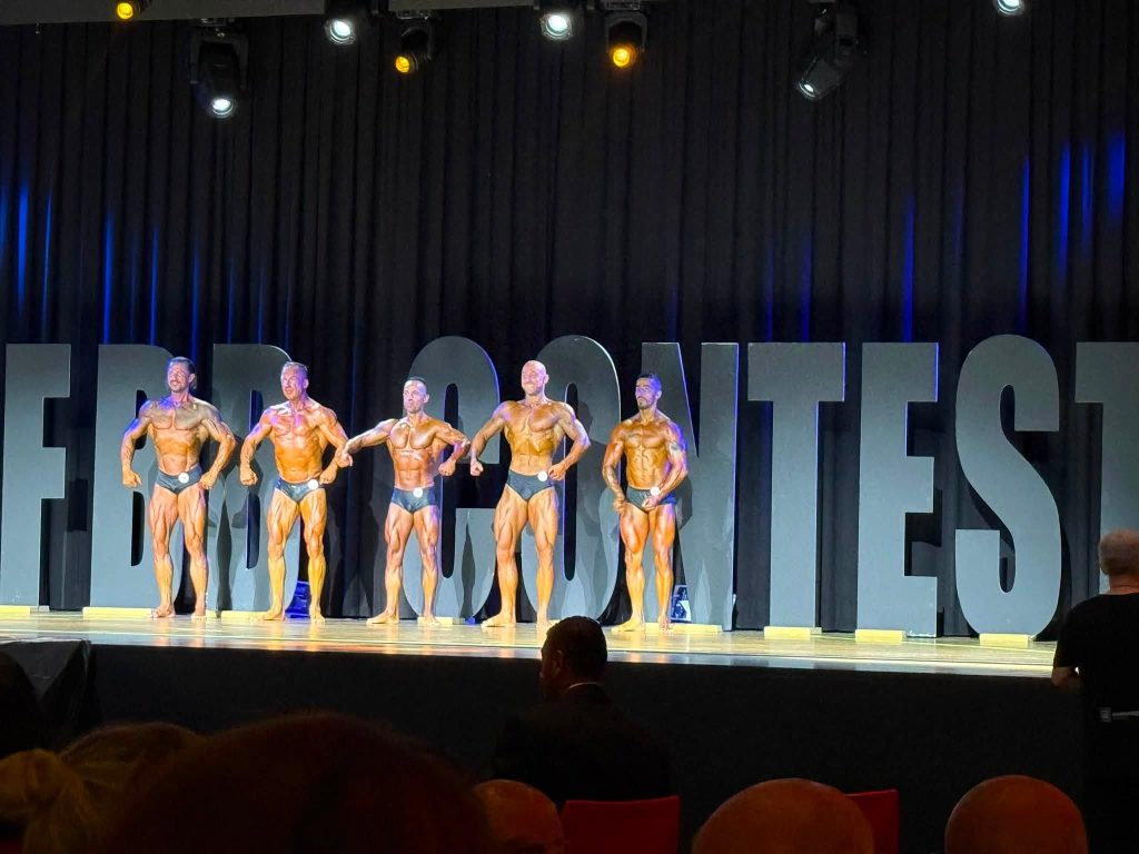 Bodybuilders posing on stage at Mr. Universe Switzerland 2026.